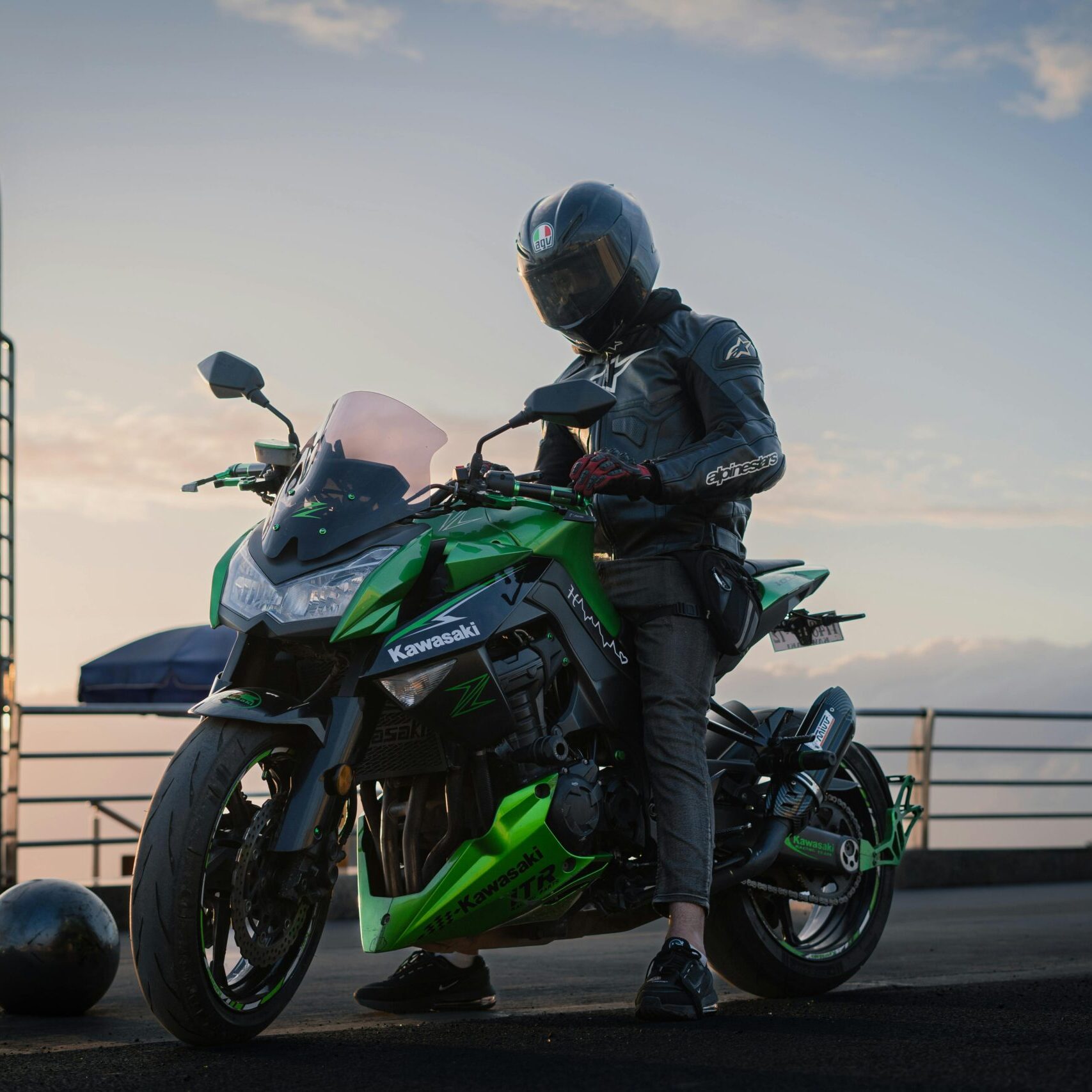 Biker on a Kawasaki Z1000 motorcycle taking a break with scenic sunset in Casablanca, Morocco.